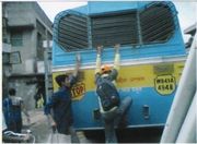 3598911-people_trying_to_climb_onto_roof_of_crowded_bus-India